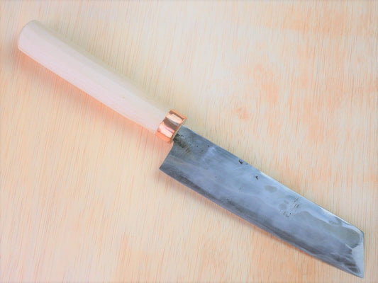 Shirogami No.3 Nakiri forged by Tsutomu Takahashi laying on wooden background with it's cutting edge facing south