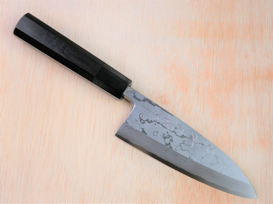 150mm Aogami Deba by Takahashikusu laying on wooden background with it's cutting edge facing south