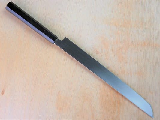 270mm VG10 Takohiki forged by Takahashikusu laying on wooden background with it's cutting edge facing north