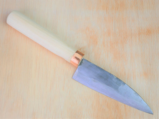 130mm Shirogami No.3 Santoku forged by Tsutomu Takahashi laying on wooden background with it's cutting edge facing south